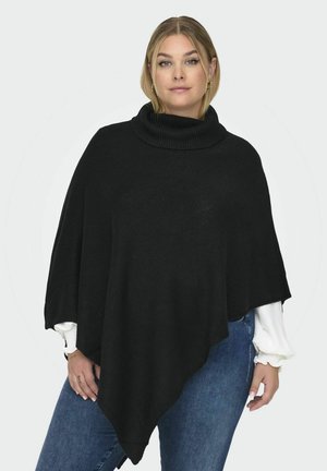 Black knit poncho with a high, ribbed cowl neckline. Features a flowing, asymmetrical hem and textured pattern. Worn over a white shirt.
