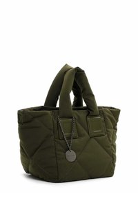 Gesteppte olivgrüne Tragetasche mit gepolsterten Griffen und einem runden Metallschild an einer Kette, das in der Nähe des Griffs befestigt ist.