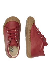 Scarpe in pelle rossa con una texture liscia, caratterizzate da punte arrotondate, suole in gomma marrone e lacci marroni con occhielli in metallo.