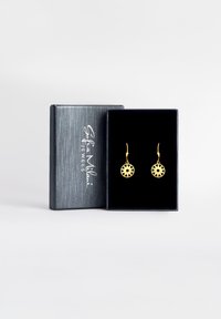 Gli orecchini d'oro presentano un design circolare con un motivo a stella intagliato, appesi a sottili ganci. Esibiti in una scatola regalo foderata di velluto scuro.