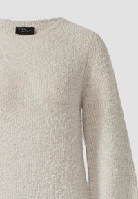 Beige, flauschiger Pullover mit weicher Textur, rundem Ausschnitt und langen Ärmeln. Zarte Glitzerakzente im gesamten Stoff.