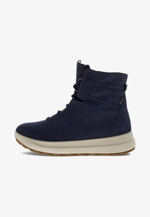 Navyblaue High-Top-Schuhe aus strukturiertem Leder mit einer gepolsterten cremefarbenen Sohle. Sie verfügen über eine Schnürung vorne und einen gepolsterten Kragen für zusätzlichen Halt.