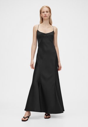 Melnas satīna maksi kleita ar plānām lencēm, piegulošu augšdaļu un zvana formas apakšu. Gluda tekstūra un vienkāršs, elegants dizains.
