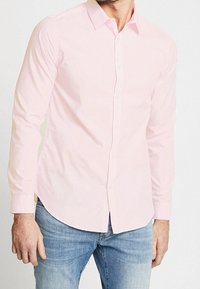 Camicia button-up rosa chiaro, maniche lunghe, design con colletto, realizzata in tessuto morbido. Presenta un orlo curvo e chiusura frontale con bottoni.