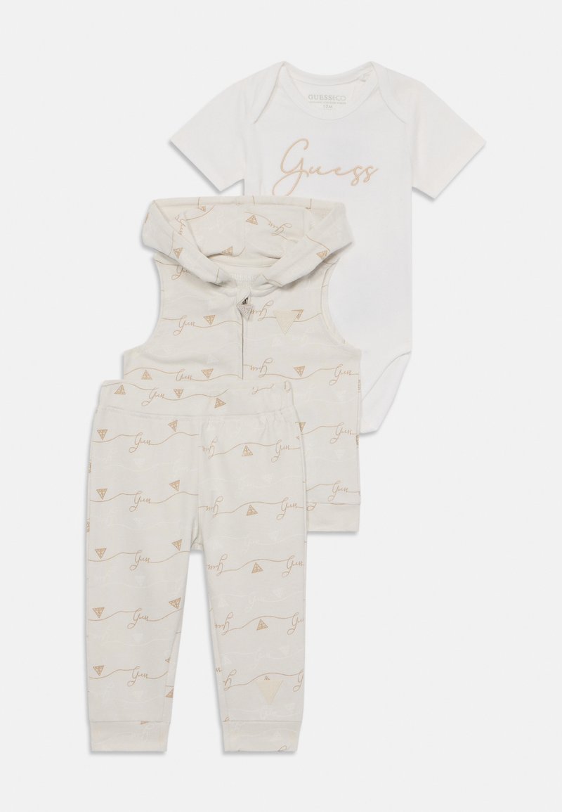 Three-piece baby outfit including a white bodysuit with gold "Guess" text, cream hoodie with patterns, and matching patterned pants.