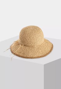 Słomiany kapelusz przeciwsłoneczny z okrągłą koroną i szerokim rondem. Naturalny beżowy kolor, z tkaną teksturą i związanym detalem u podstawy.