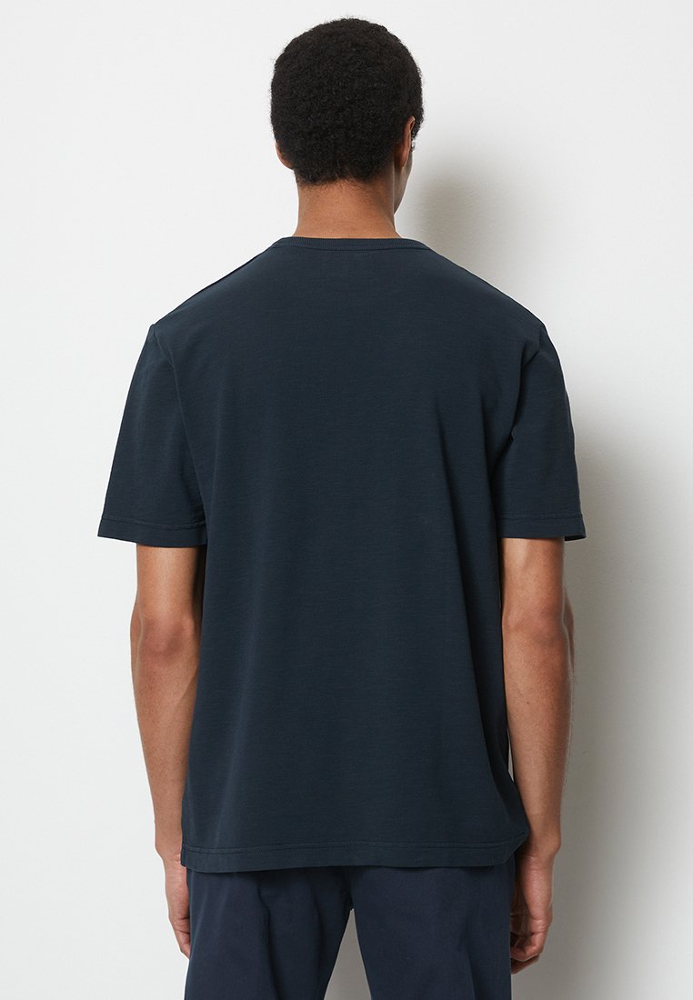 Granatowa koszulka z krótkim rękawem wykonana z bawełny, z okrągłym dekoltem, luźnym krojem i gładką fakturą, bez widocznych logo i zdobień.
