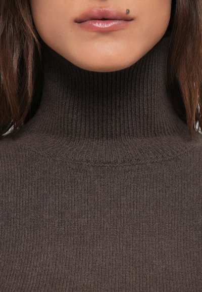 Pulover din lână maro cu guler înalt, cu un design ajustat și o textură moale, având striuri orizontale subtile.