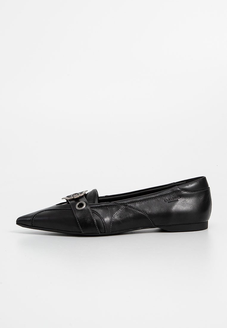 Botte plate en cuir noir avec un bout pointu, accent de boucle décorative et couture horizontale sur le dessus. Semelle profil bas.
