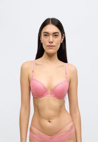 Ροζ σουτιέν δαντέλα με κυματιστές άκρες, ρυθμιζόμενες τιράντες και γεωμετρικά μοτίβα· εσωτερική μπανέλα για στήριξη· λείο υλικό.