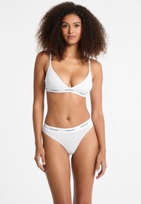 Weißes Baumwoll-Bralette mit verstellbaren Trägern und Logobund; passende weiße Baumwollbikini mit Logobund. Einfaches und tailliertes Design.