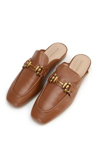 Mule in pelle marrone con punta quadrata, dotati di hardware dorato e una fascia decorativa lungo la parte superiore. Texture liscia su tutta la superficie.