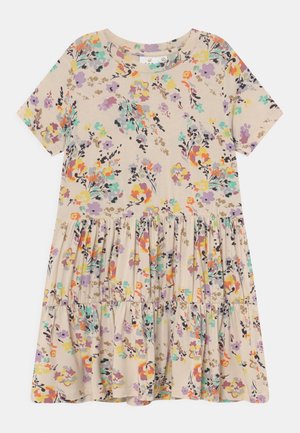 Bloemig korte mouwjurk met een gelaagde rok, op een beige achtergrond met kleurrijke bloemen, gemaakt van zachte, lichte stof.