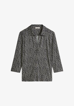 Chemise noire à manches longues avec boutons, ornée d'un petit motif floral blanc, et un col pointu.