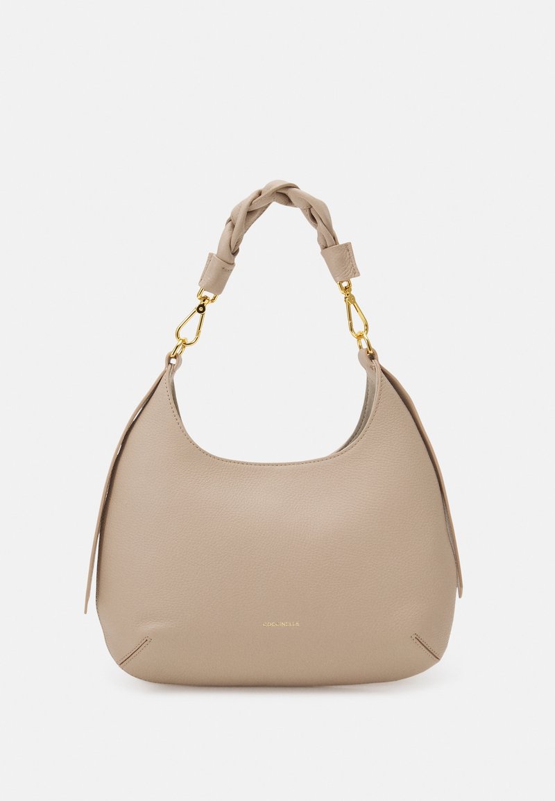 Beżowa skórzana torebka z plecionym uchwytem, złotymi akcentami, zakrzywionym kształtem i subtelnie wytłoczonym logo z przodu.