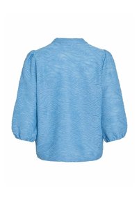 Lys blå topp med et strukturert bølgemønster, puff-ermer og rund halslinning. Stoffet ser mykt og litt gjennomsiktig ut.