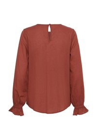 Raundivärvi blouse pika varrukaga, tekstureeritud kangas, võtmeaugu dekolteega seljaosas ja volangidega varrukaotsad. Mugav lõige ja ümar äär.