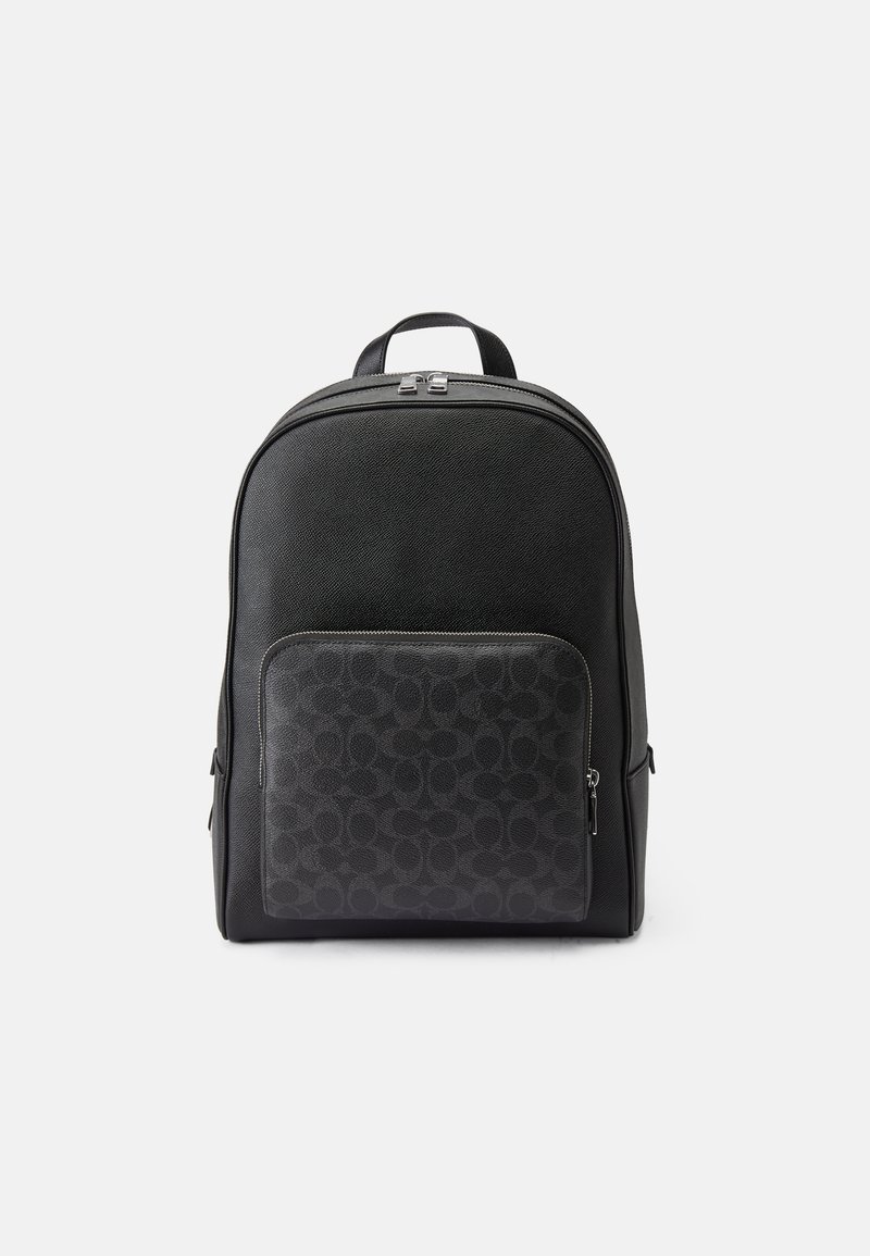 Mochila de couro preto com acabamento liso, apresentando um bolso frontal em tecido estampado, fecho de zíper duplo e alças ajustáveis.