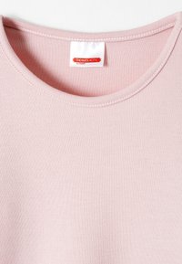 Haut rose clair à manches courtes et col rond fabriqué en tissu doux et extensible. Comprend une étiquette portant la mention "THERMOLACTYL par DAMART." Texture lisse.