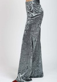 Pantaloni in velluto, a vita alta, con gamba larga in grigio argento, caratterizzati da una texture liscia e riflettente e un lieve motivo su tutta la superficie.