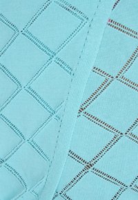 Lichtblauwe gebreide stof met een diamantpatroon en open steken, die een gladde textuur en gedetailleerde afwerking laat zien.