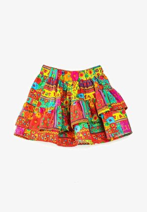 Jupe à volants colorée avec des motifs en patchwork de fleurs, d'instruments de musique, de crânes et de textes dans des teintes vives de rouge, jaune, bleu et vert.