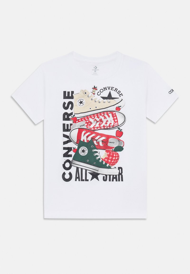 Camiseta de algodón blanca con un gráfico de cuatro zapatillas apiladas en beige, rojo y verde, con el texto "Converse All Star" y acentos de manzana.