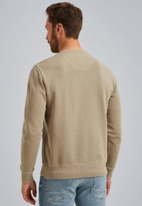 Beige crewneck sweatshirt met lange mouwen en ribgebreide manchetten. Zachte, gestructureerde stof in een comfortabele pasvorm. Minimalistisch ontwerp, zonder patronen of accenten.