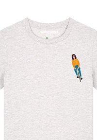 T-shirt en coton gris clair avec un graphique imprimé représentant une personne à vélo, vêtue d'un pull orange et d'un jean bleu.