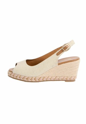 Beige Stoffkeilsandalette mit offenem Zehenbereich, Knöchelriemen, goldener Schnalle und geflochtener Seilsohle.