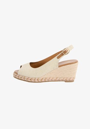 Sandalo con zeppa in tessuto beige, punta aperta, cinturino alla caviglia, fibbia dorata e suola in corda intrecciata.