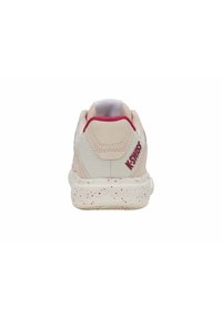 Tenisky K-Swiss, s horní částí v světle růžové barvě a texturovaným designem, a bílou podešví posetou růžovými akcenty. Zobrazeno ze zadní strany.