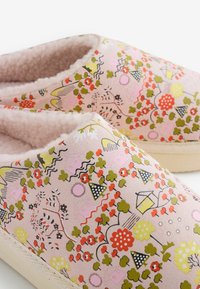 Zachte roze slippers met kleurrijke bloemen- en huispatronen, voorzien van een pluche beige binnenvoering en lichte beige zolen.
