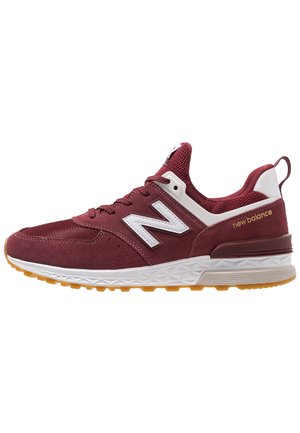 Maroonfarbener New Balance Sneaker mit weißem „N“-Logo, Mesh- und Wildlederobermaterial, weißer Zwischensohle und Gummiaußensohle, seitlich betrachtet.