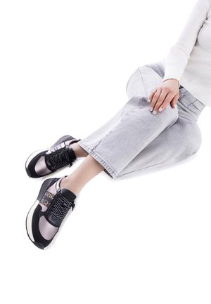 Zapatillas deportivas en negro y gris con una parte superior texturizada, puntera redonda y cordones. Tienen una suela gruesa y un patrón distintivo en los laterales.