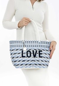 Borsa a spalla intrecciata in blu, bianco e nero con un motivo a zigzag. Presenta la scritta "LOVE" in feltro blu navy, manici intrecciati bianchi e un charm.
