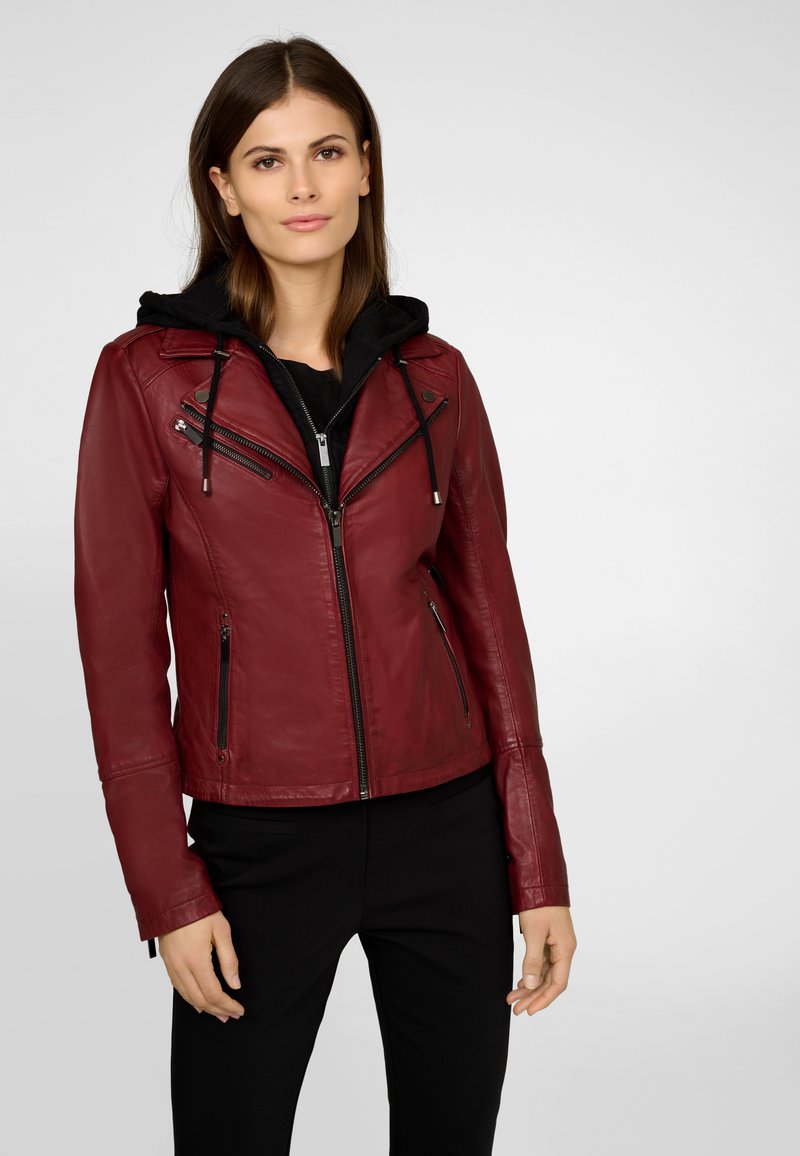 Veste de moto en cuir rouge avec fermeture éclair sur le devant, poches latérales et capuche noire. Présente un design ajusté et des accents en métal argenté.