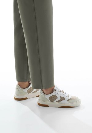 Sneaker bianche e beige con accenti testurizzati, design con lacci e suole in gomma. Indossate con pantaloni larghi di colore verde oliva.