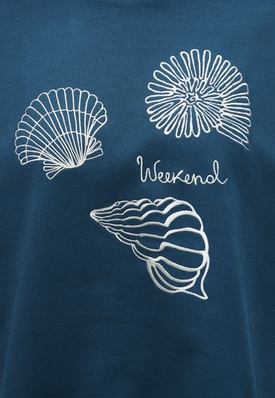 Μπλε ύφασμα με λευκά κεντημένα περιγράμματα τριών διαφορετικών κοχυλιών και τη λέξη "Weekend" με καλλιγραφικά γράμματα.
