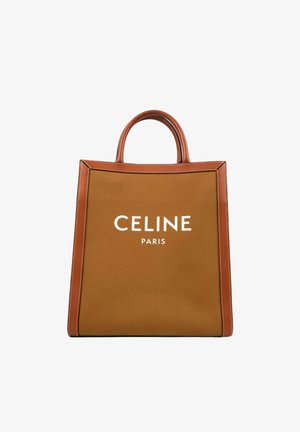 Brązowa torba typu tote z płótna i skóry z górnymi uchwytami, z białym logo "CELINE PARIS" z przodu.