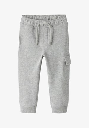 Pilkos medvilninės jogger tipo kelnės su elastinga juosmens juosta, raišteliu, šoninėmis kišenėmis, krovinine kišene dešinėje kojoje ir raukšlėmis ant kulkšnių.