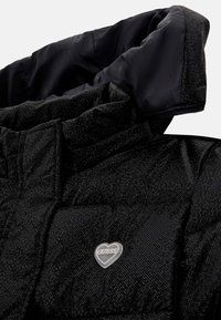 Chaqueta acolchada negra con cuello alto, tejido texturizado, logo en forma de corazón y un forro interior brillante en contraste. Presenta un diseño acolchado.