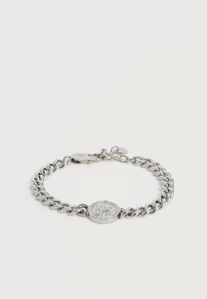Silver chain bracelet with a round religious medallion and lobster clasp closure on a plain white background.
