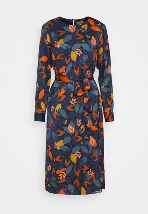 Marineblaues Kleid mit langen Ärmeln, einem bunten Muster aus orangen, gelben und türkisfarbenen Blättern sowie einem passenden Stoffgürtel, der in der Taille gebunden ist.