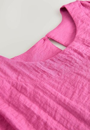 Rosa linne-top med rundad halslinje och en liten skärning i ryggen, med texturerad tyg och subtila sömnadsdetaljer.