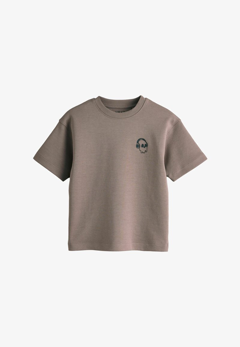 T-shirt marron court à col rond avec manches courtes, ornée d'une petite tête de mort noire portant un casque audio imprimée sur le côté gauche de la poitrine.