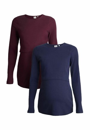 Twee langemouwen tops: één mahonie, één marineblauw. Beide hebben een geribde textuur en een ronde halslijn met een ontspannen pasvorm.