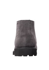 Botín de ante gris con suela de goma negra plana. Presenta una puntera redondeada y costuras mínimas en el talón. Textura suave en general.