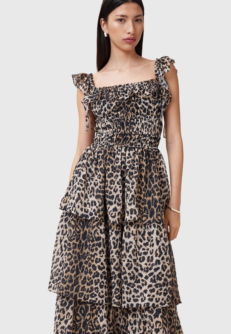 Abito maxi in stampa leopardata con strati di rouches, corpetto arricciato e spalline scese. La palette di colori include tonalità di beige e nero.