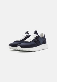 Ciemnoniebieskie sneakersy z mieszanki zamszu i tkaniny, z grubymi białymi sznurówkami, białą podeszwą i teksturowanym wykończeniem cholewki.